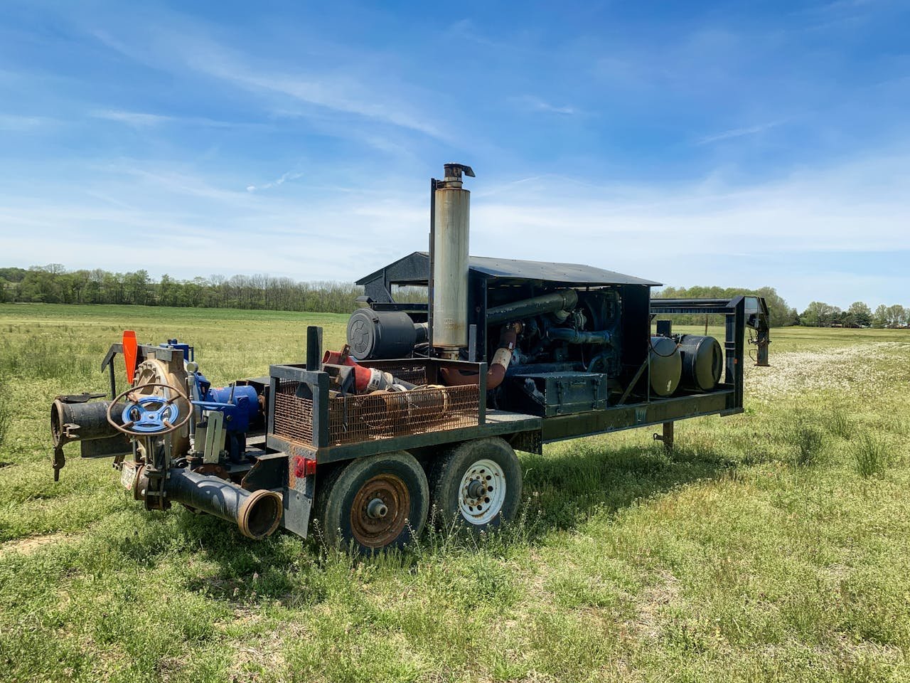 Diesel engine water pump in a Smithville field under clear sky.